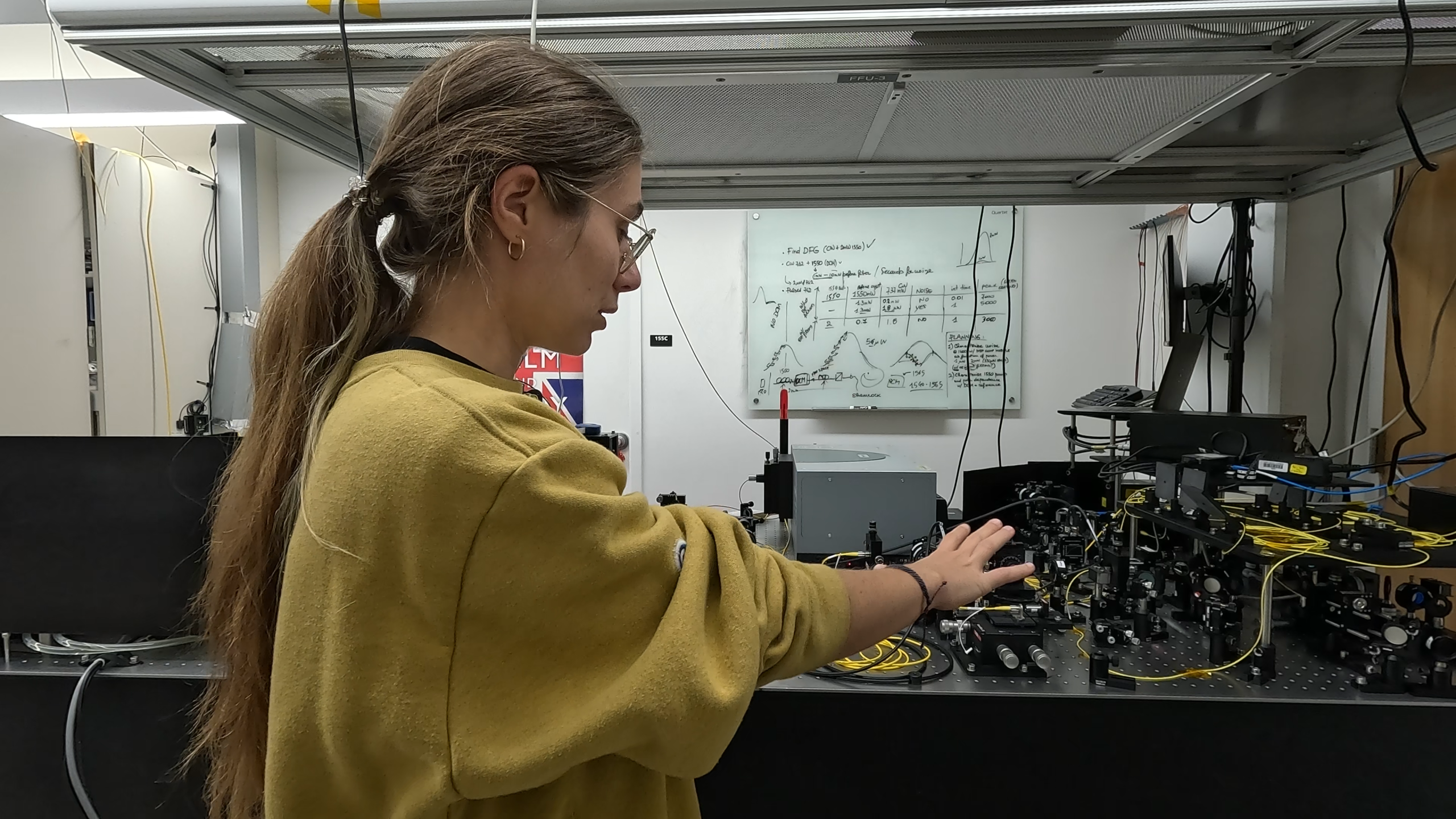 Francesca Sansavini in her lab Researcher pointing at the optical table, as to explain the content of it